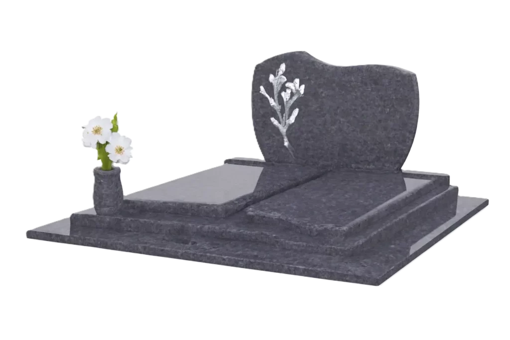 Monument funéraire en granit gris poli avec stèle gravée et fleurs blanches.